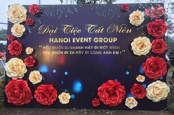 Băng rôn tất niên in trên bề mặt hiflex/PP hoặc băng rôn kết hợp với hoa giấy gắn nổi.