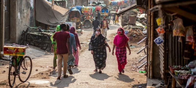 Phụ nữ đeo khẩu trang khi đi qua khu chợ ở Dhaka, Bangladesh