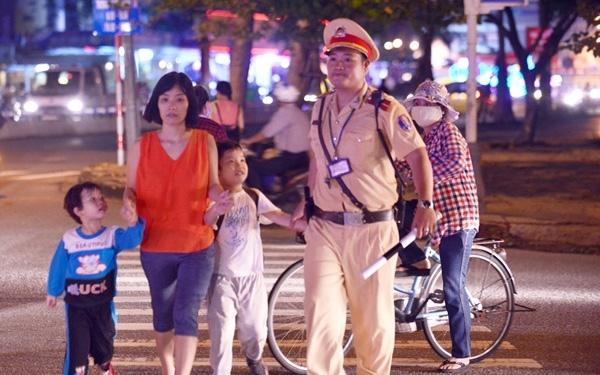 Công an giao thông dẫn người dân qua đường lúc đang làm nhiệm vụ
