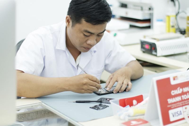 Kỹ thuật viên FPT Shop tỉ mỉ sửa chữa điện thoại cho khách