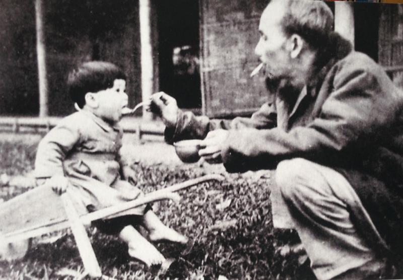 Bác Hồ bón cơm cho cháu bé khi đến thăm một trại nhi đồng ở Việt Bắc, năm 1950