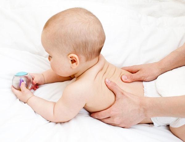 Xoa lưng bé thành những hình tròn để giúp bé bớt cảm giác đau bụng.