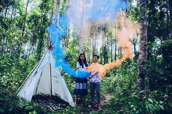 Hai bạn trẻ đang chụp ảnh đôi  phong cách cắm trại với pháo màu