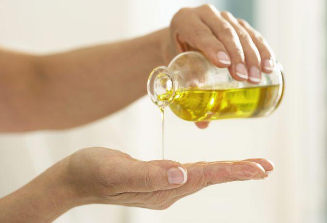 Xoa dầu dừa vào lòng bàn tay rồi massage quanh móng